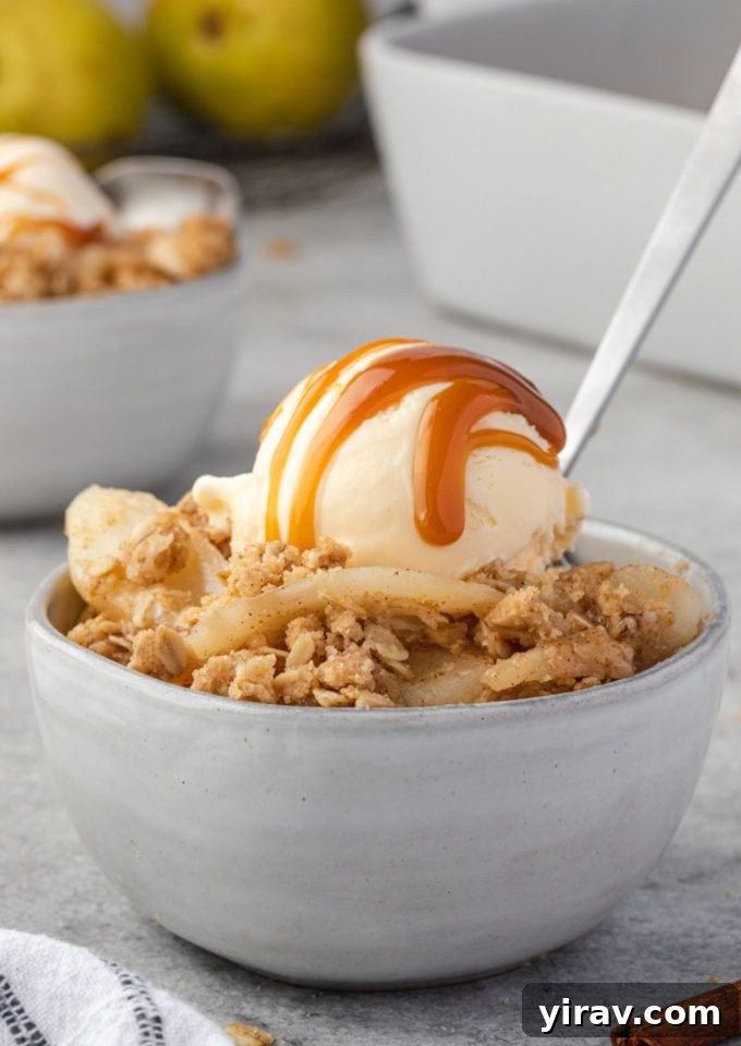 Pear crumble in a bowl with ice cream and caramel
