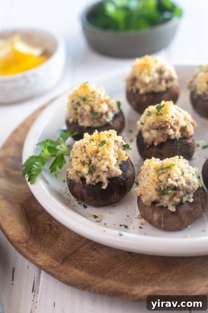 Sausage stuffed mushrooms on a plate with parsley