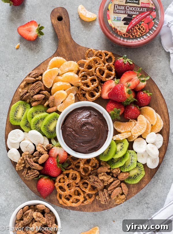 Snack board with chocolate hummus, fruit and pretzels