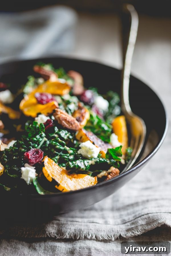 A large bowl of vibrant Thanksgiving Salad with roasted delicata squash, fresh chèvre, and spiced pecans.