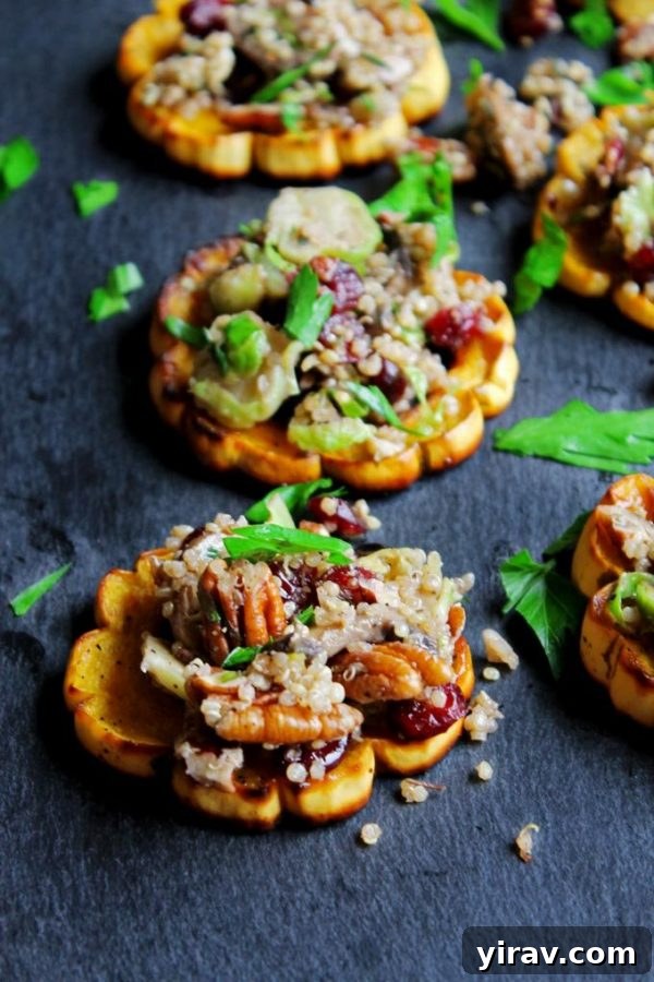 A baking sheet showcasing beautifully arranged quinoa stuffed delicata squash rings, a colorful and healthy vegan dish.
