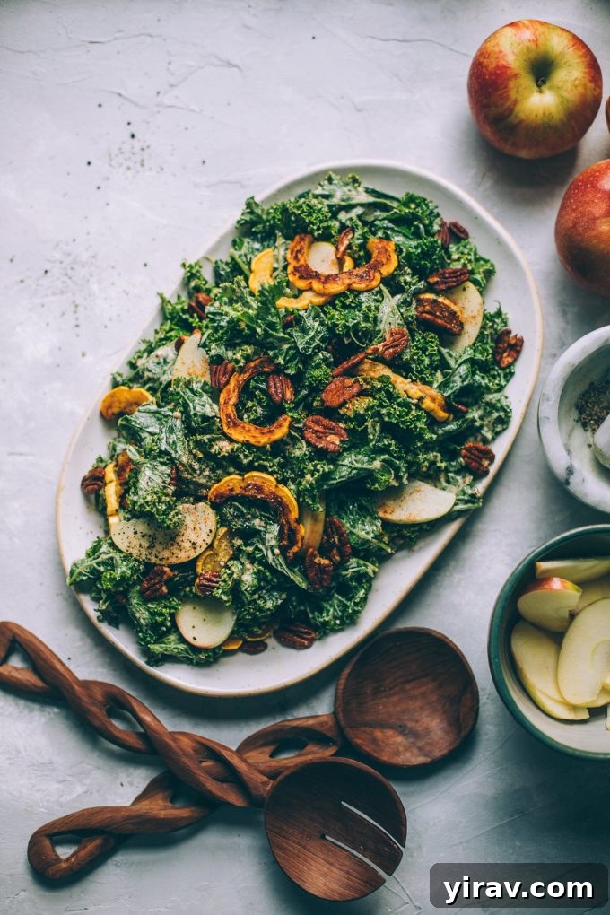 A large, inviting bowl of Kale Caesar Salad featuring roasted delicata squash, showcasing a creamy maple mustard dressing.