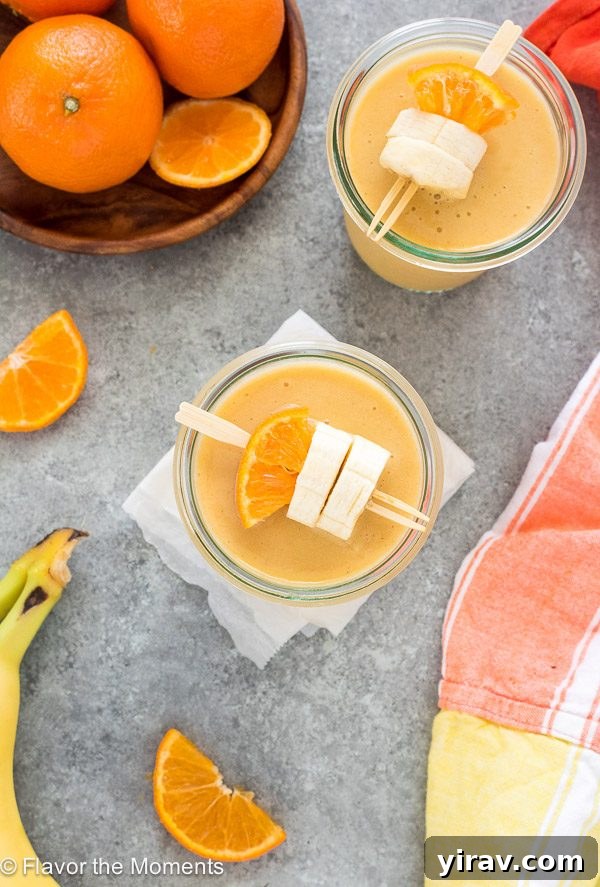 Citrus Cream Dream 5 Close-up of orange creamsicle smoothie in a jar, with orange and banana slices on a skewer for garnish