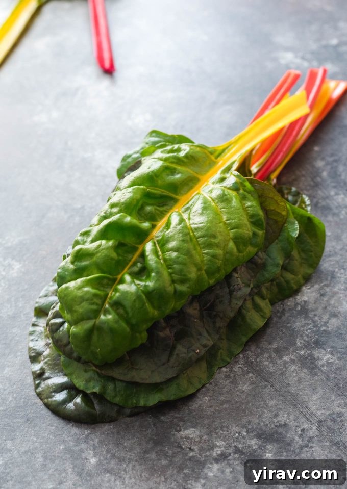 Vibrant rainbow chard leaves stacked neatly, showcasing their rich colors and fresh texture, hinting at the healthy recipes within this guide.