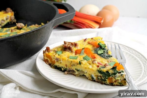 A slice of Farmers Market Frittata on a white plate, showcasing its colorful ingredients and fluffy texture.