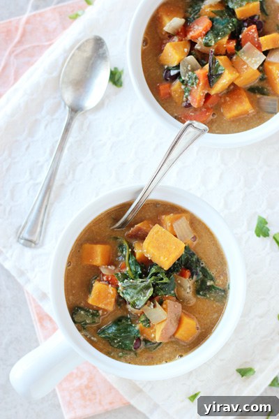 A comforting bowl of creamy sweet potato and Swiss chard soup with a spoon, inviting warmth and healthy goodness.