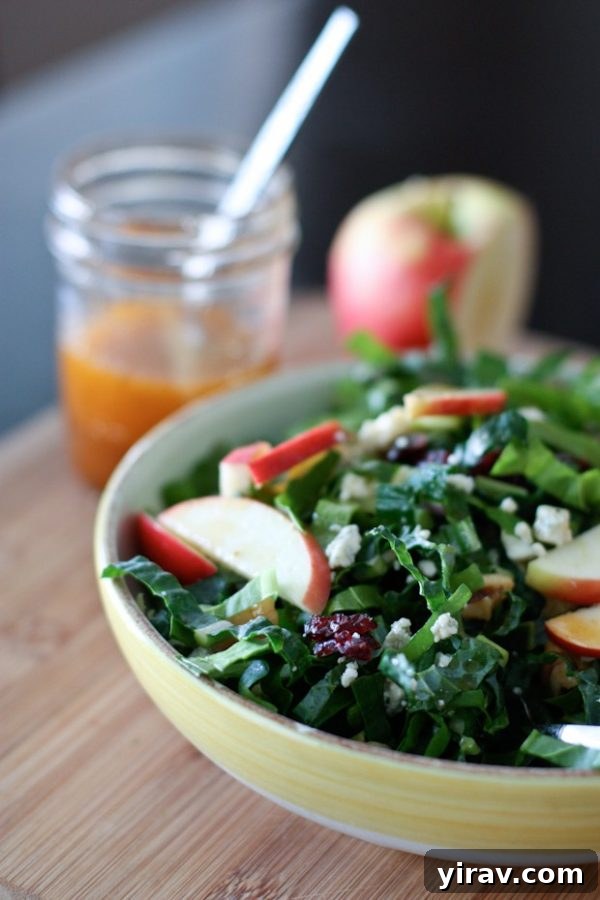 A fresh kale and chard salad in a bowl, topped with crisp apple slices, offering a vibrant and healthy mix of greens.