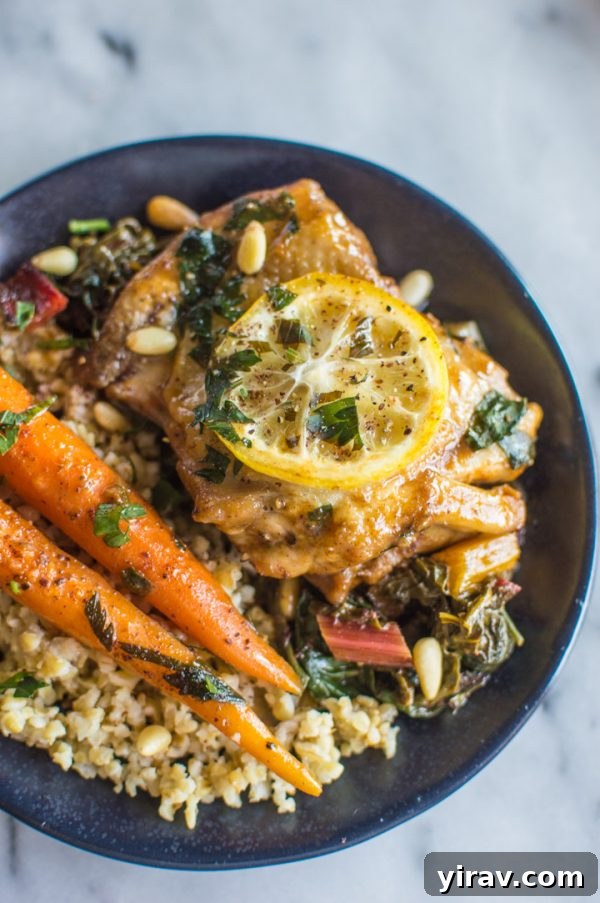 A dish of One-Pan Braised Lemon Paprika Chicken with Sumac, featuring tender chicken and a bright lemon slice garnish.