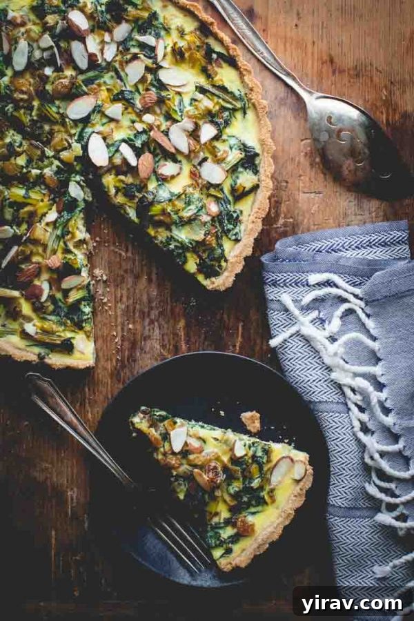 A slice of elegant Swiss chard tart with Chevre and Leeks, served on a plate, highlighting its rich filling and flaky crust.