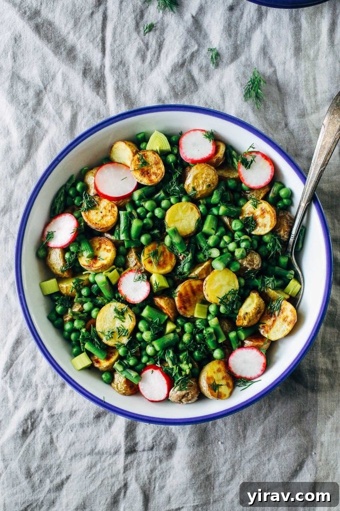 Spring potato salad in a bowl with a serving spoon