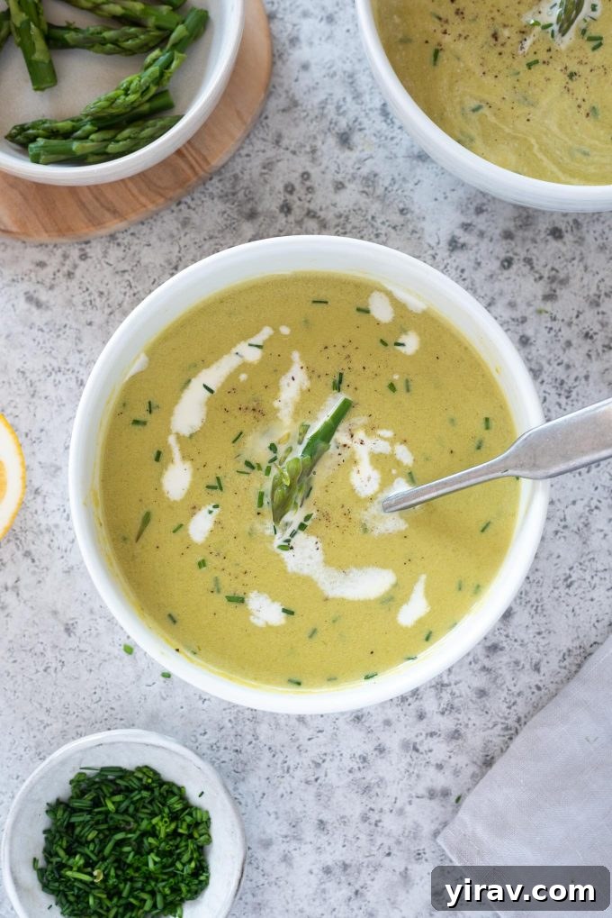 Creamy asparagus soup in a bowl with chives on top
