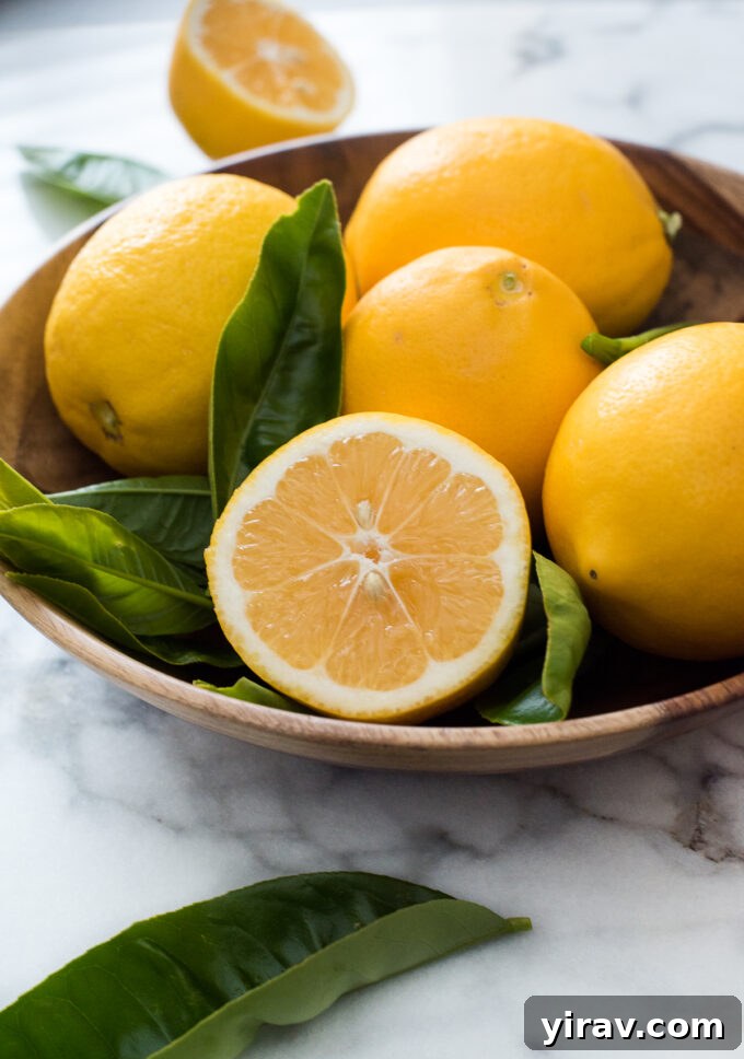 Close-up of fresh Meyer lemons and a microplane zester, ready for use in baking.