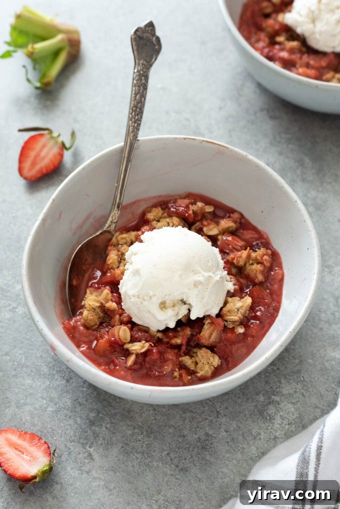 23 Rhubarb Recipes Essential Produce Guide 14 A bowl of warm Strawberry Rhubarb Crisp topped with a generous scoop of melting vanilla ice cream.