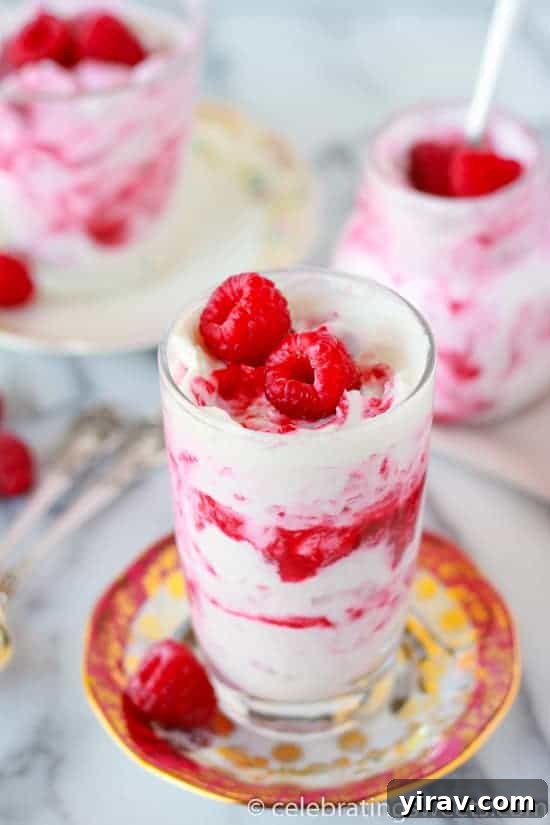 23 Rhubarb Recipes Essential Produce Guide 19 A glass of exquisite Raspberry Rhubarb Fool, elegantly topped with fresh raspberries, with more jars in the background.