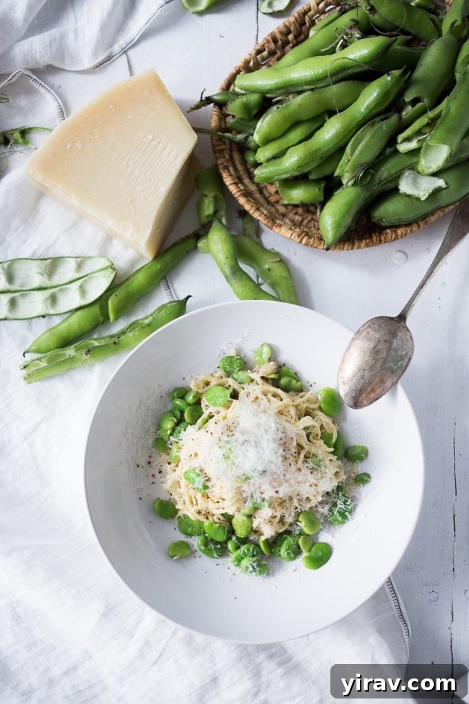 Classic Cacio e Pepe pasta dish enhanced with fresh fava beans, served in a rustic bowl.