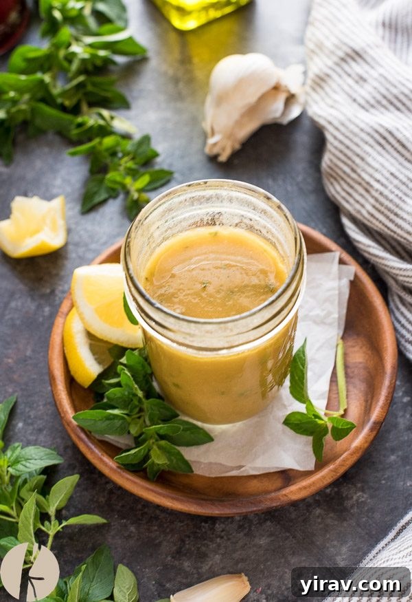 Greek dressing in mason jar with oregano and lemon