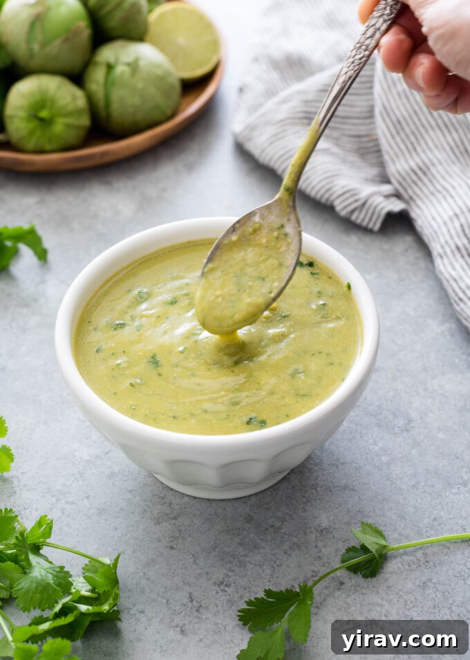 Homemade green enchilada sauce pouring from a spoon