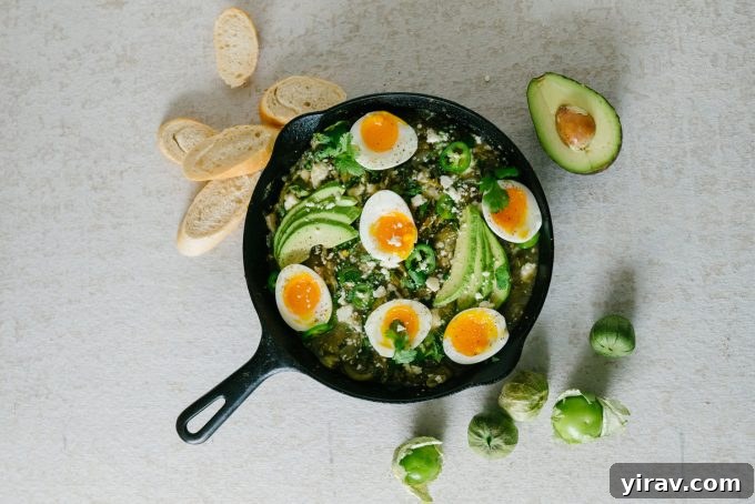 Overhead view of green shakshuka in a cast iron skillet.