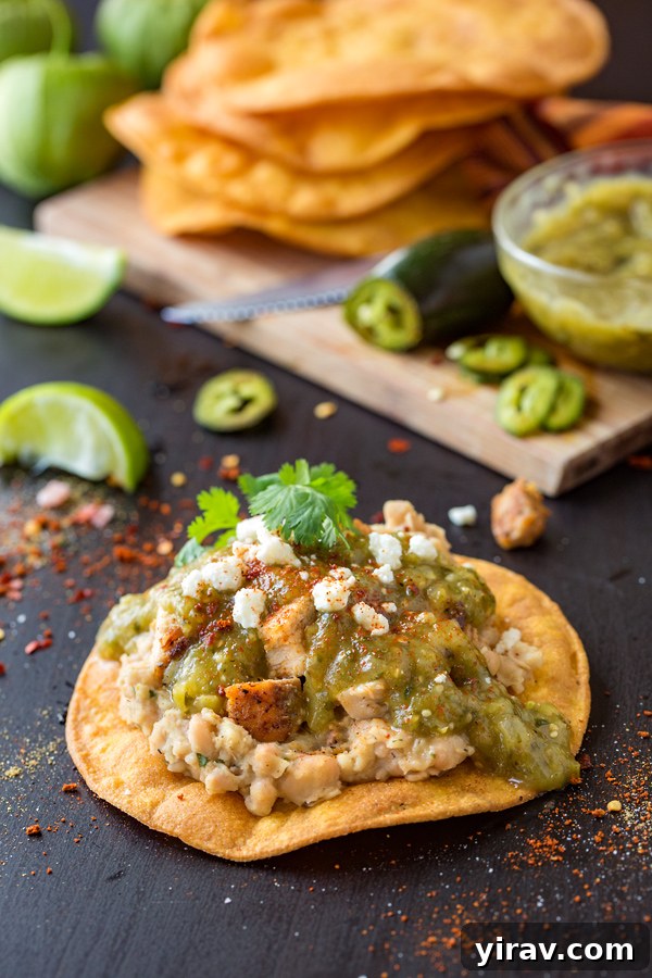 A chicken tostada topped with tomatillo salsa.