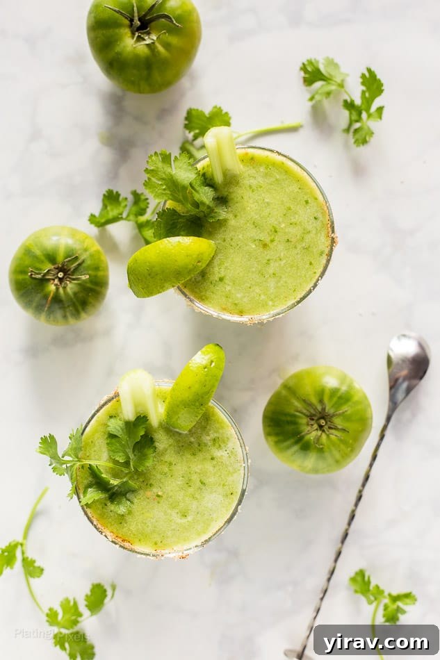 Overhead view of two green bloody marys in glasses.