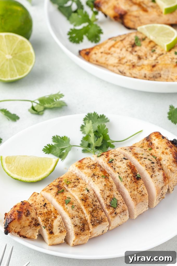 Perfectly sliced grilled tequila lime chicken breast on a white plate
