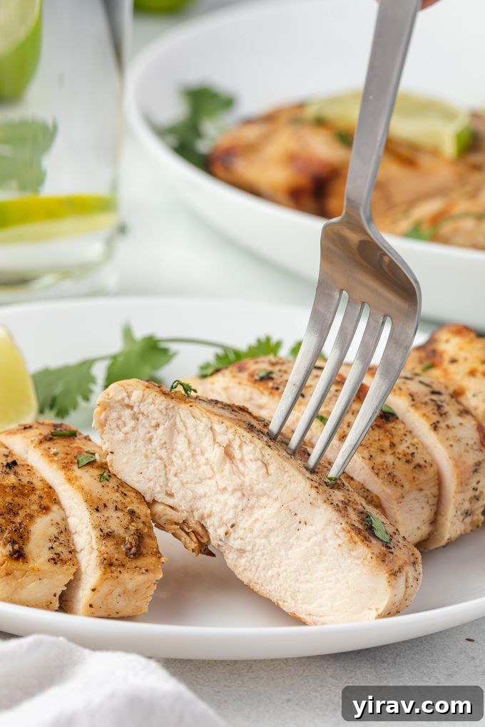 A fork taking a bite of sliced tequila lime chicken