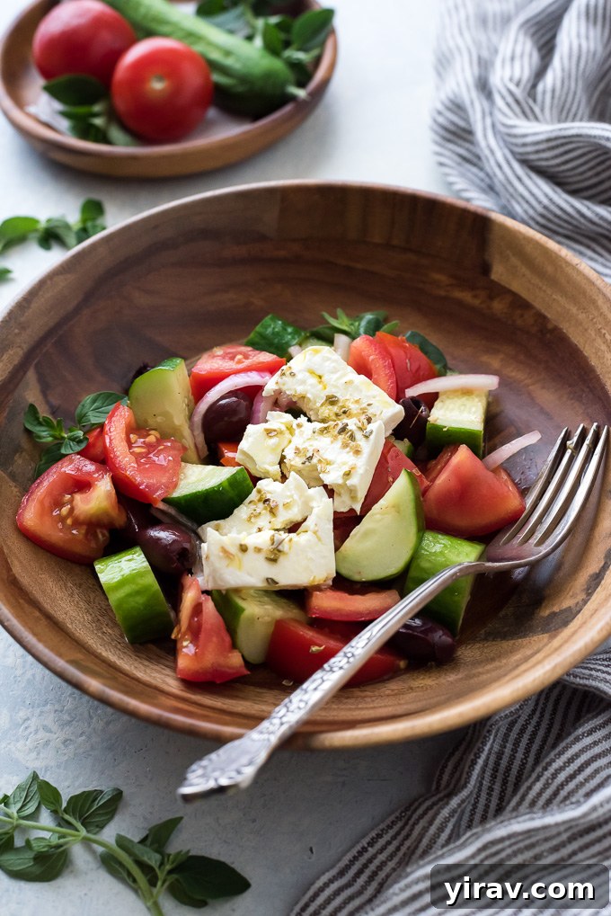 Greek horiatiki salad with crumbled feta on top, styled for serving