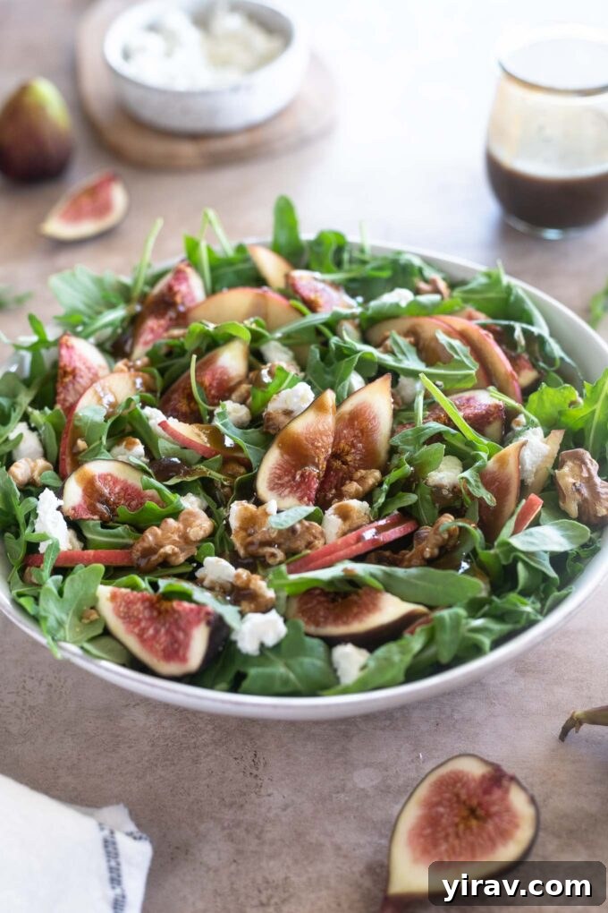 Arugula Fig Salad in a white bowl with balsamic dressing drizzled over it, ready to serve.