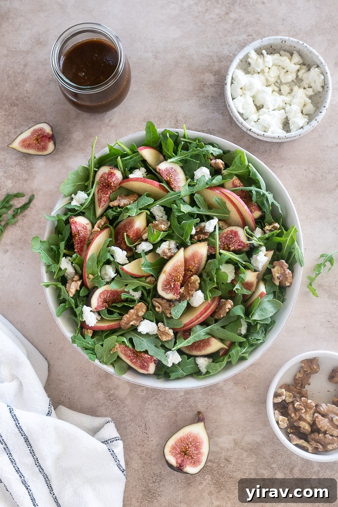 Close-up shot of Arugula Fig Salad in a white serving bowl, showing the textures of figs, goat cheese, and walnuts.