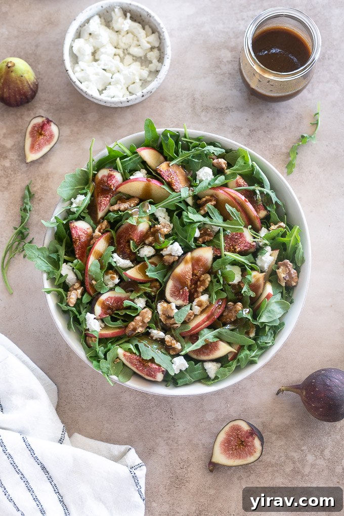 A beautifully presented fig and goat cheese salad, with balsamic dressing generously drizzled, ready for serving.