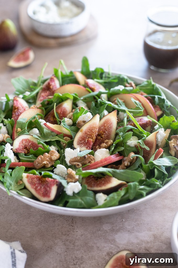 Un-dressed apple fig salad in a white bowl, showing fresh ingredients before balsamic dressing is added.