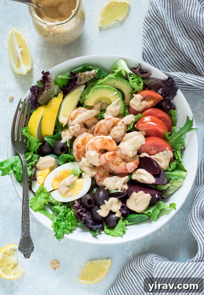 Close-up of a vibrant Shrimp Louie salad with a fork, ready to be enjoyed, highlighting its fresh appeal.