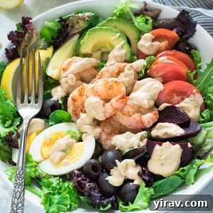 Shrimp Louie salad drizzled with Louie dressing, presented beautifully.