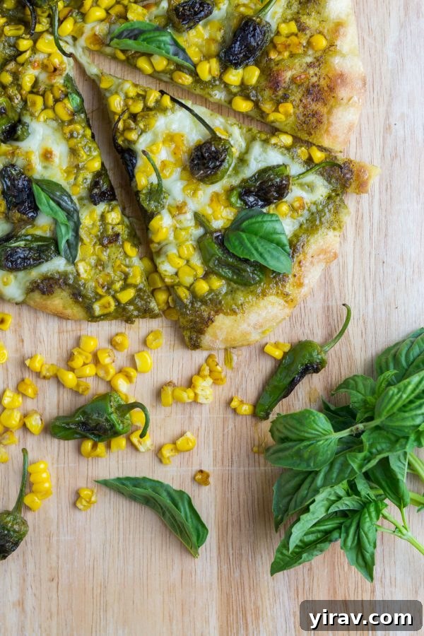 Overhead view of corn shishito pepper pizza sliced