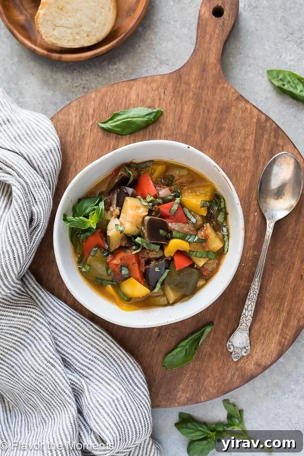 Effortless Instant Pot Ratatouille 3 An overhead shot of a delightful bowl of ratatouille served on a wooden cutting board with a spoon, highlighting its fresh ingredients.