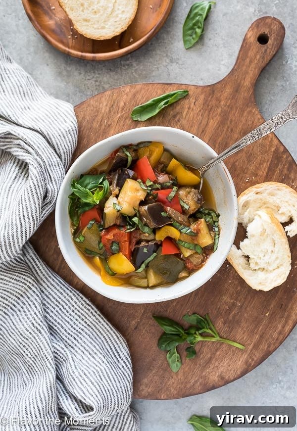 Effortless Instant Pot Ratatouille 6 A close-up shot of a bowl of ratatouille with a spoon nestled inside, ready to be served alongside fresh bread.