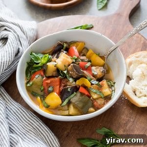 bowl of instant pot ratatouille with spoon in the bowl and bread alongside