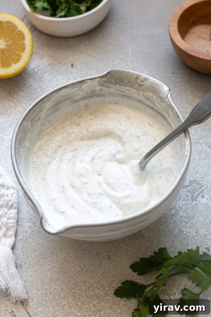 Greek yogurt ranch dressing in a bowl with a spoon.