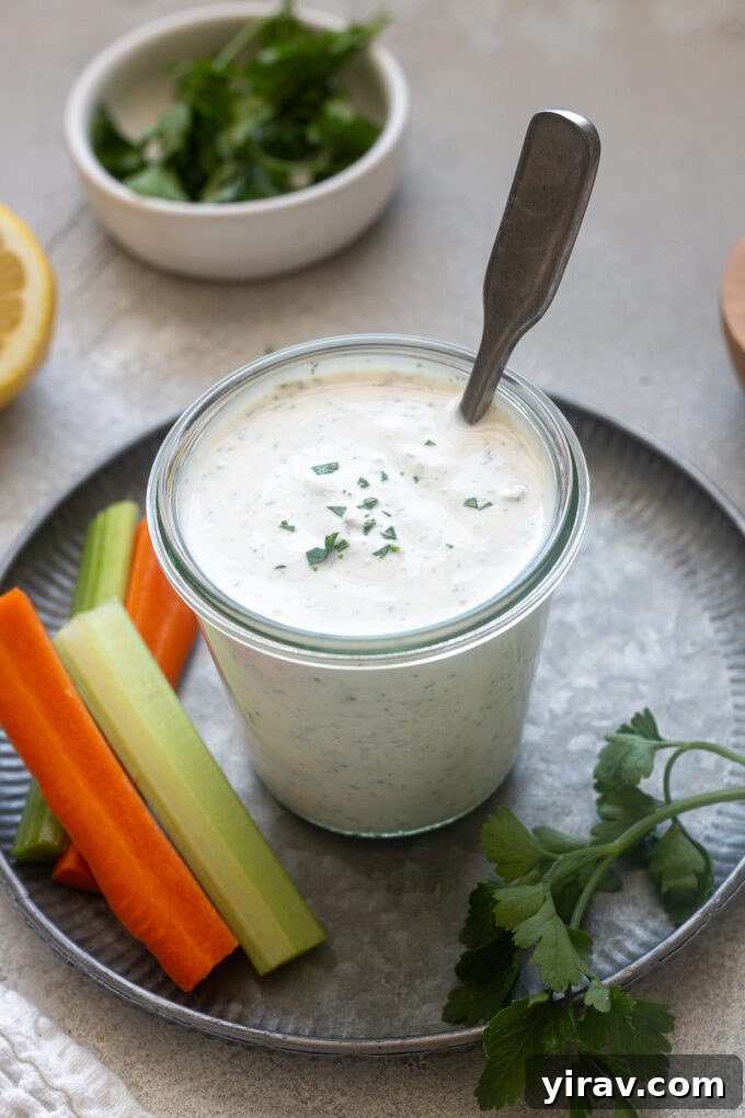 Jar of Greek yogurt ranch dressing in a jar with parsley on top.