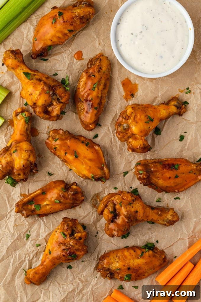 Close-up of golden, crispy Instant Pot buffalo chicken wings arranged on parchment paper, ready to be tossed in sauce.