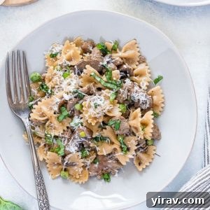 Sausage and bow tie pasta on a plate with a fork.
