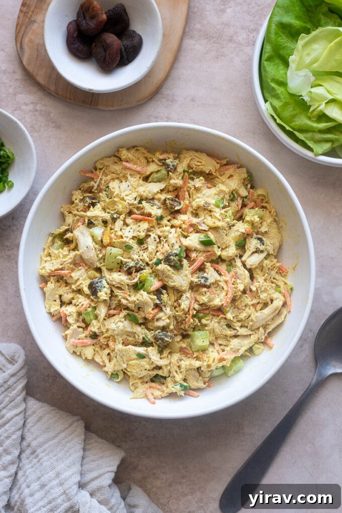 Curry chicken salad in a serving bowl, perfectly creamy and inviting with a garnish of fresh herbs.