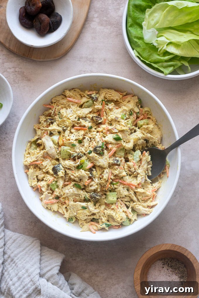 Close-up of chicken salad with creamy curry dressing in a white serving bowl, garnished with fresh cilantro.