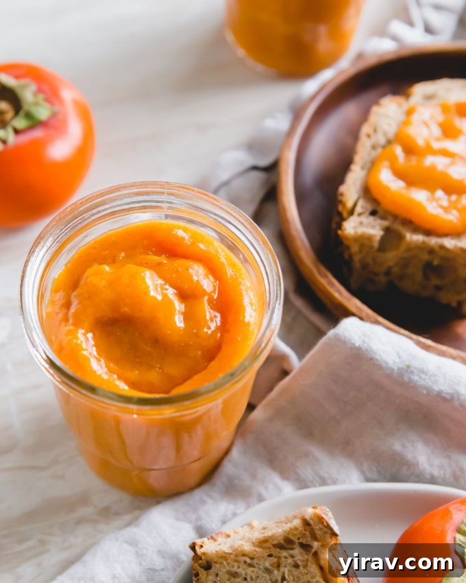 A jar of homemade persimmon jam, featuring its rich, amber color.