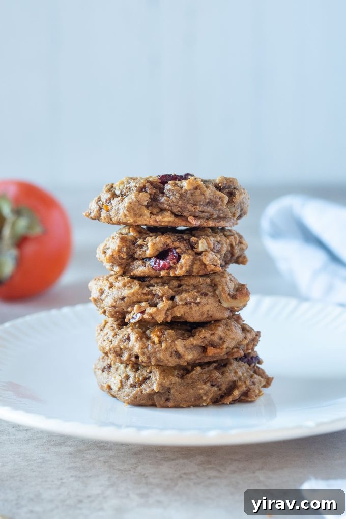 A stack of soft and chewy persimmon oatmeal cookies on a white plate.