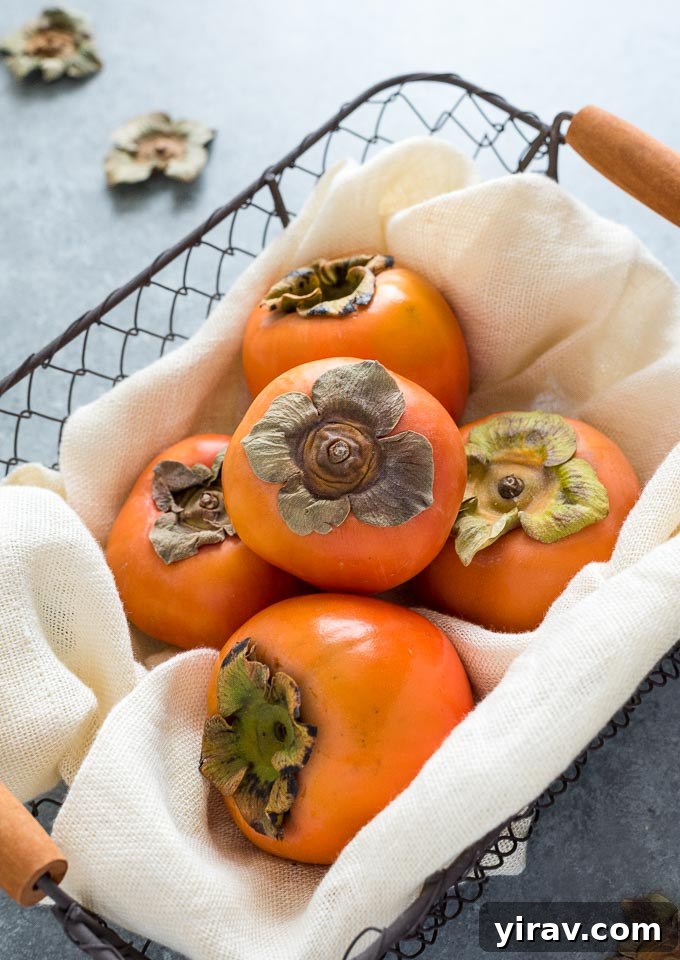 Several ripe persimmons displayed in a rustic linen-lined basket.
