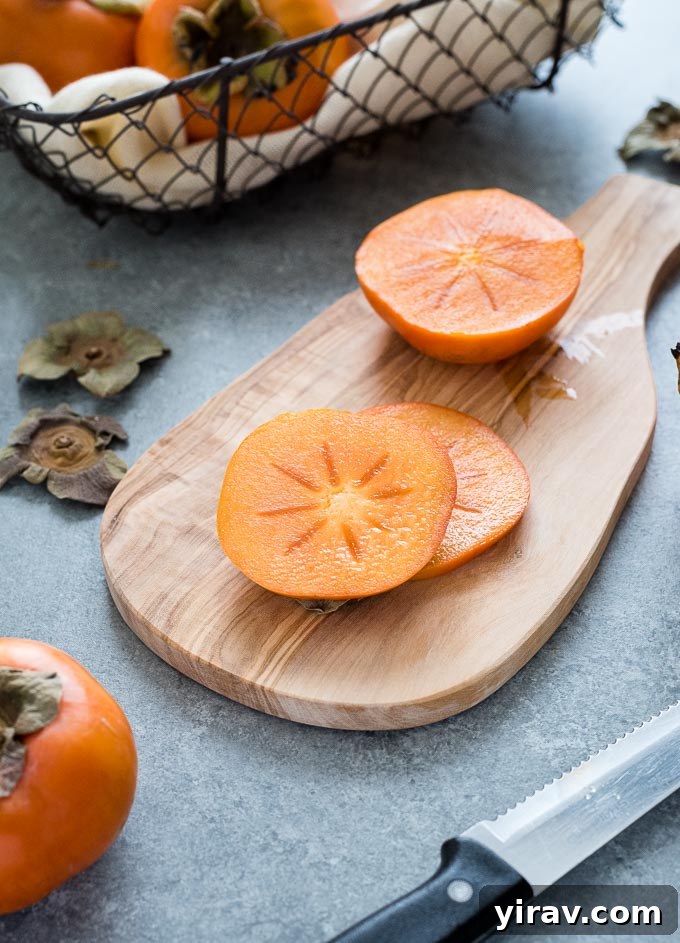 Fuyu persimmon slices neatly arranged on a wooden cutting board, ready for use.