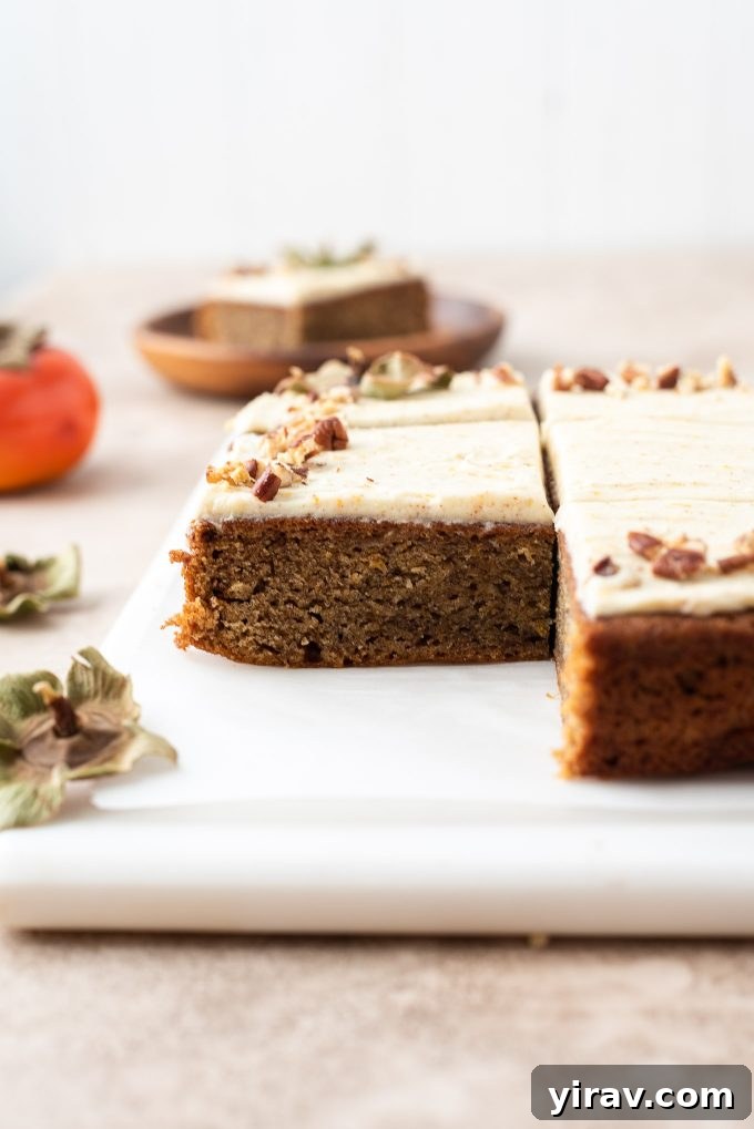 A beautifully presented slice of persimmon cake on a marble board, ready to be served.