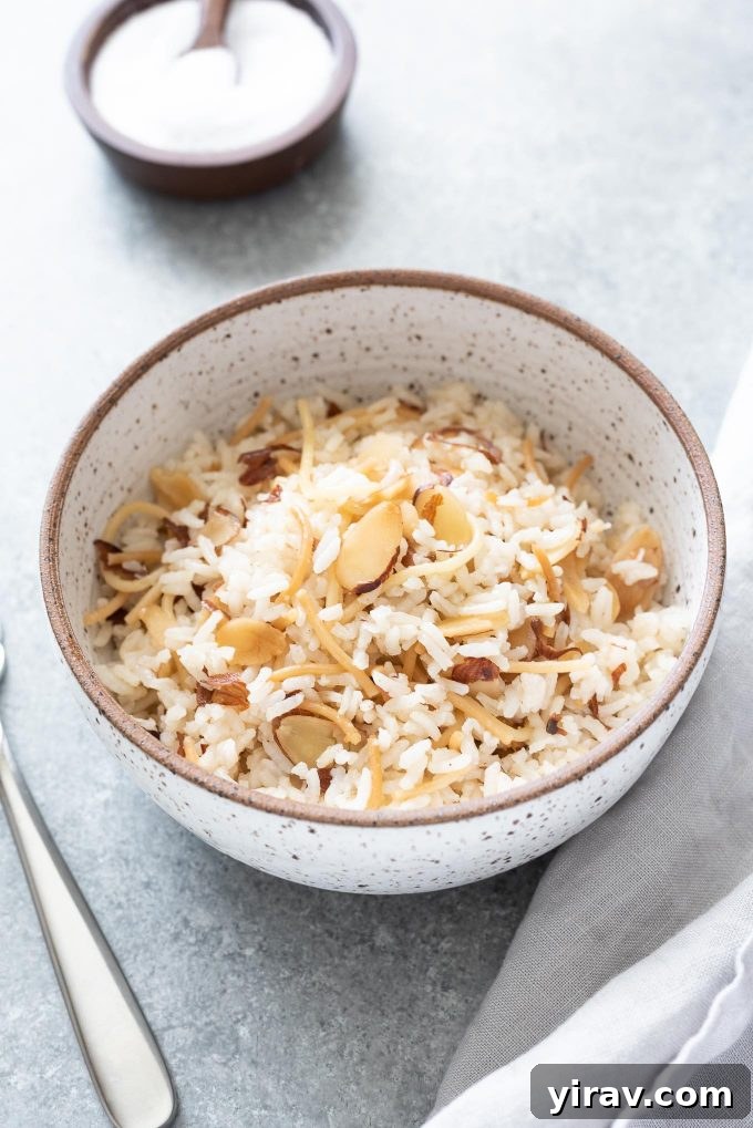 Bowl of almond rice pilaf with fork and linen