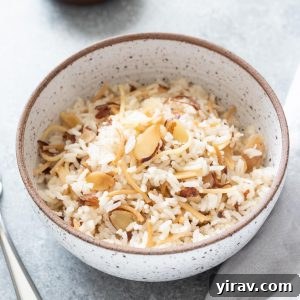 Bowl of almond rice pilaf with fork and linen